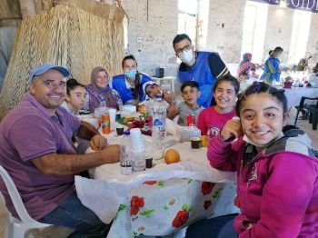 Helfer von Sant'Egidio beim Abendessen im Gespräch mit Menschen aus dem Lager Moria.