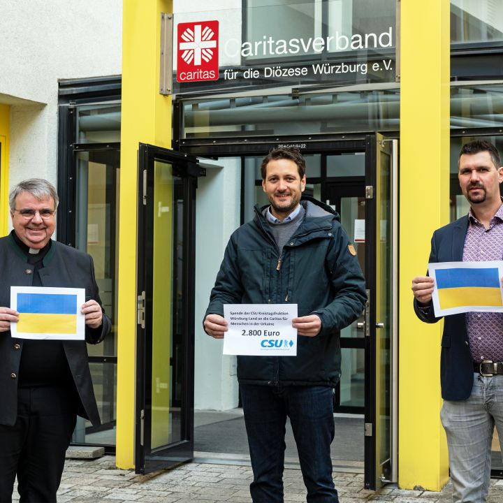 Einen symbolischen Spendenscheck für die Flüchtlingsarbeit der Caritas übergaben die CSU-Kreisräte Björn Jungbauer (Mitte) und Thomas Haaf (rechts) an Domkapitular Clemens Bieber (links), Vorsitzender des Diözesan-Caritasverbands.