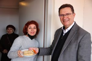 Svetlana Pavlichuck überreicht als Zeichen der Dankbarkeit gefüllte Pfannkuchen an Dekan Dr. Andreas Krefft. 