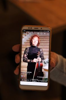 Svetlana Pavlichuck zeigt auf ihrem Handy Fotos, die sie bei der Arbeit als Orchestermusikerin zeigen.